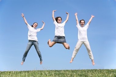 Three girlfriends in white T-shorts jump having waved hands clipart