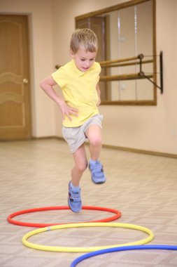 Boy makes exercise ith hoops clipart
