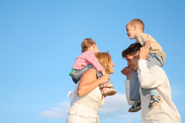 Father and mother with the children on the shoulders 2 clipart