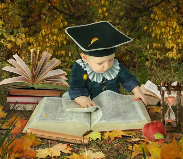 Маленький мальчик с большим количеством книг в коллаже осеннего парка — стоковое фото
