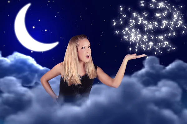 Una chica sostiene algo en una mano en el cielo con una luna y estrellas —  Fotos de Stock