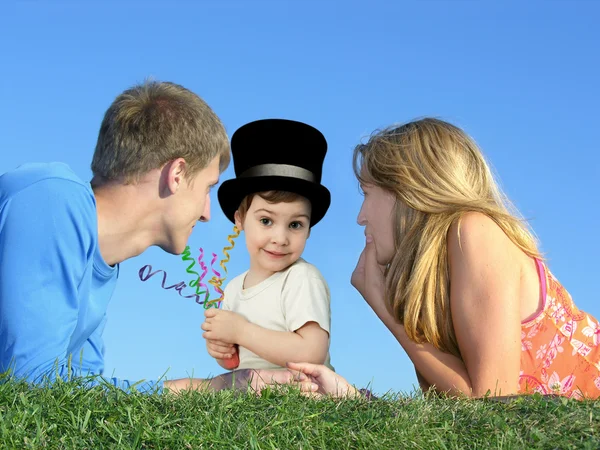Child in a hat with a mother and father on a grass, collage — Stock Photo, Image
