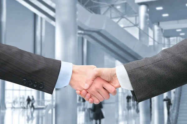 Shaking hands with wrists in hall of business center collage — Stock Photo, Image