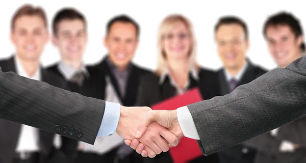 Shaking hands with wrists and six business group out of focus co — Stock Photo, Image