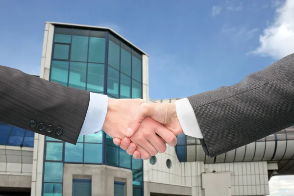 Shaking hands with wrists near blue building — Stock Photo, Image