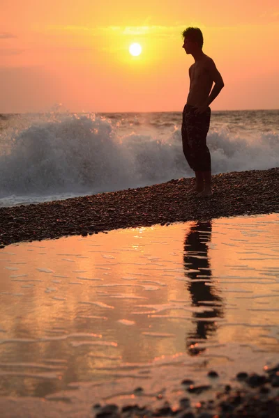 Silhouette guy on sunset wavy beach — Stock Photo, Image