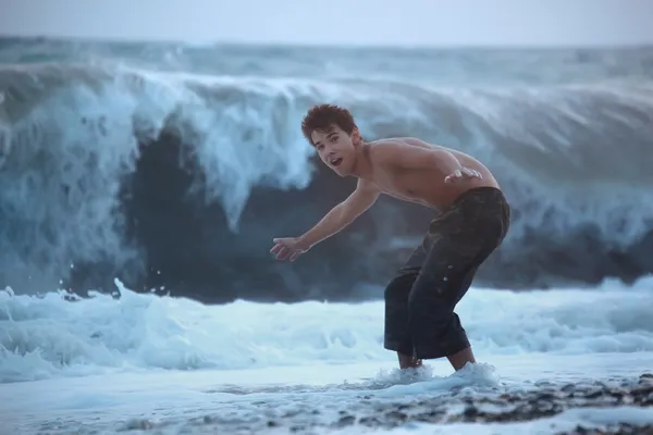 Adolescente escapando de la ola del mar —  Fotos de Stock