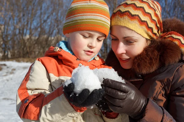 Mãe com o filho brincar com neve ao ar livre — Fotografia de Stock