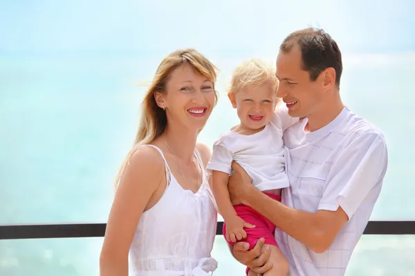 Glückliche Familie mit kleinem Mädchen auf Veranda am Meer — Stockfoto