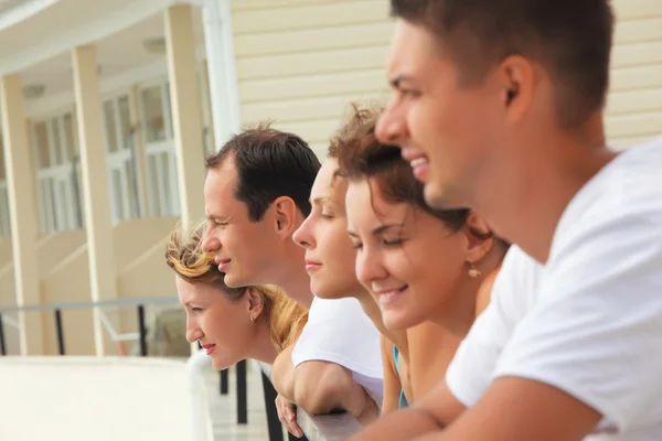 Pięciu przyjaciół uśmiechający się na balkonie — Zdjęcie stockowe