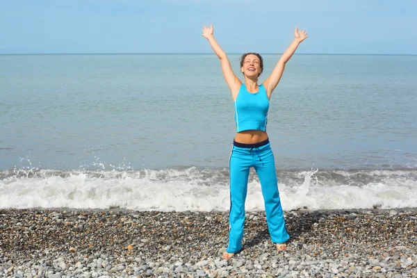 Mujer está haciendo ejercicio en la costa del mar —  Fotos de Stock