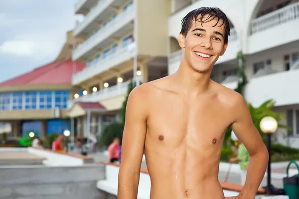 Мальчик-подросток, стоящий возле отеля на курорте вечером, подросток — стоковое фото