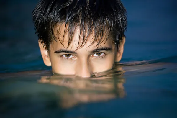 Ragazzo adolescente che nuota in piscina di notte, avendo immerso sugli occhi i — Foto Stock