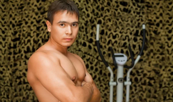 Strong bodybuilder training muscles in gym, posing at camera — Stock Photo, Image