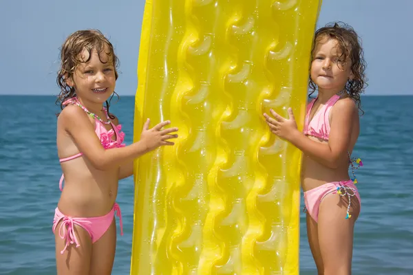 Iki küçük kız sahilde duran, bir infla denetiminizden — Stok fotoğraf