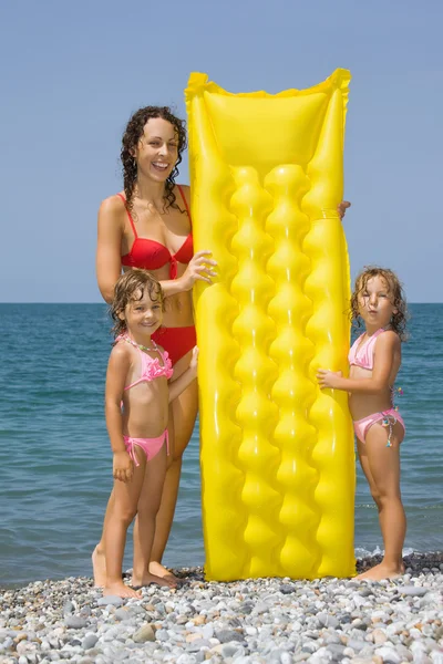 Genç kadın ve sahilde duran, sensörüne sahip iki küçük kız — Stok fotoğraf