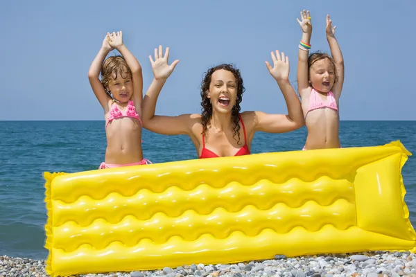 Mulher nova e duas meninas pequenas que estão atrás de um m inflável — Fotografia de Stock
