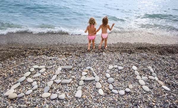 Надпись с камня Пляж на каменистом побережье, два довольно мало — стоковое фото