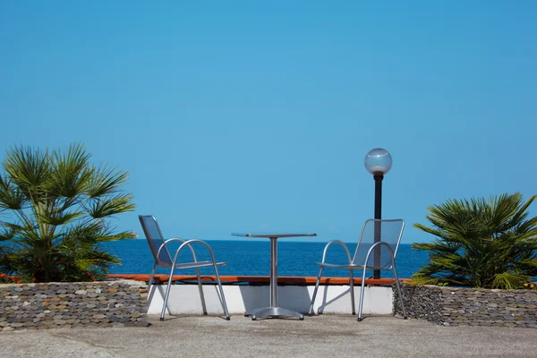 Table and chairs on beach — Stock Photo, Image