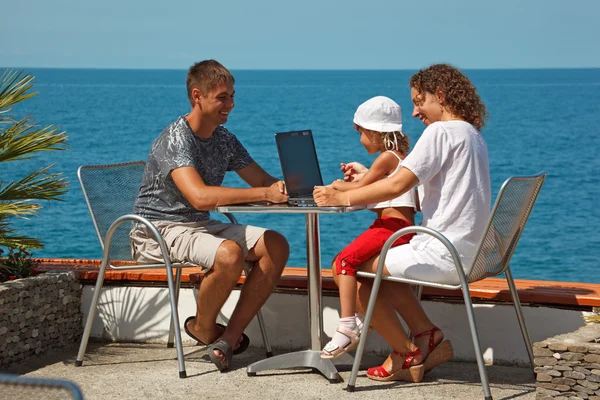 Familie ruht sich mit Laptop auf See aus — Stockfoto