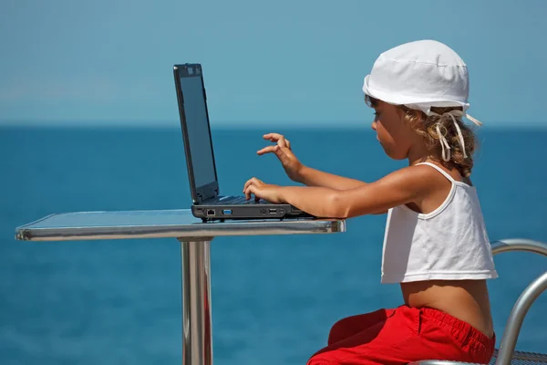 Liten flicka sitter vid laptop — Stockfoto