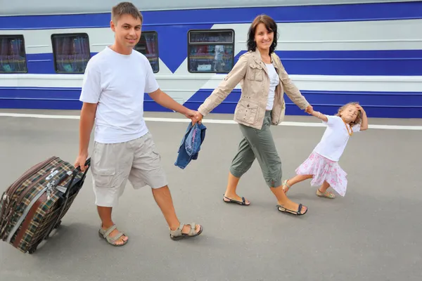 Familia feliz con la niña que va en la estación de tren — Foto de Stock