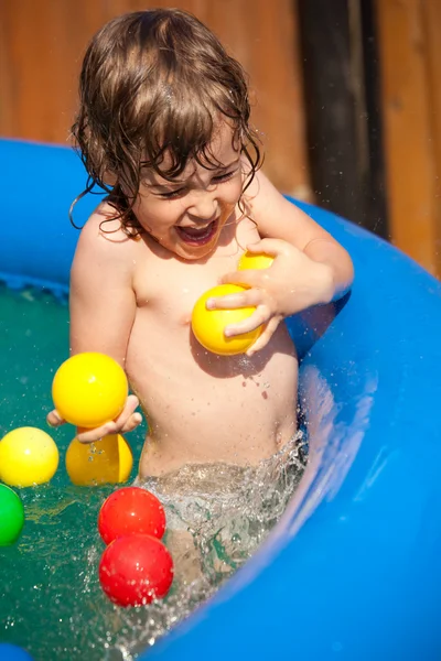 A criança toma banho na piscina inflável — Fotografia de Stock