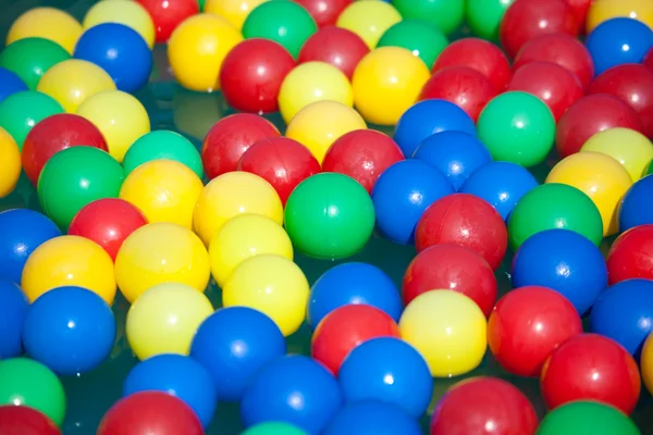 Multi-coloured balls float on water — Stock Photo, Image