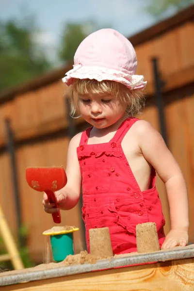 Dziewczyna gra na pewien skrzynka z piaskiem. formacie pionowym. — Zdjęcie stockowe
