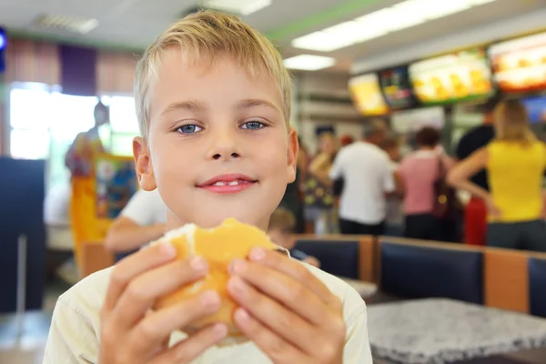 Boy eats hamburger — Stok fotoğraf