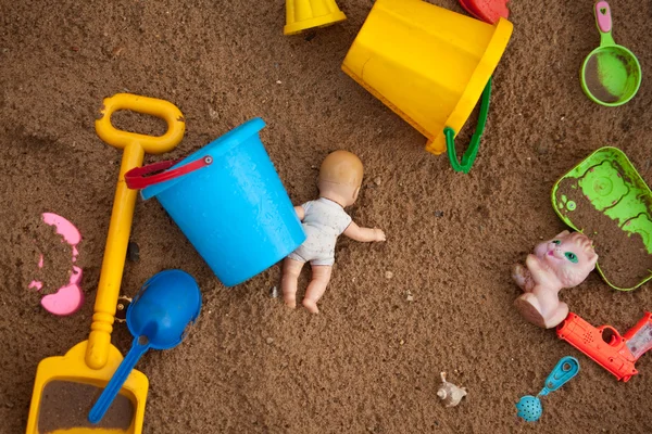 Os brinquedos lançados em uma caixa de areia — Fotografia de Stock