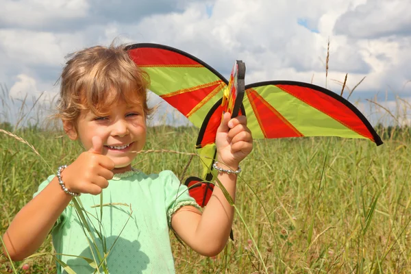 Little girl plays kite on meadow with ok gesture — Stock Photo, Image