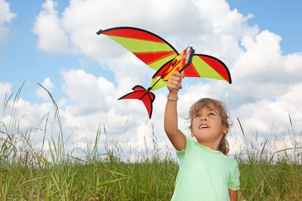 Liten flicka spelar kite på äng — Stockfoto