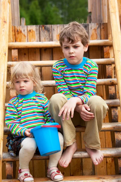 The brother and sister on a children's playground in identical c — Stock Photo, Image