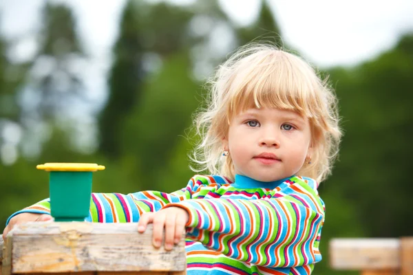 Портрет девочки на детской площадке с игрушкой — стоковое фото