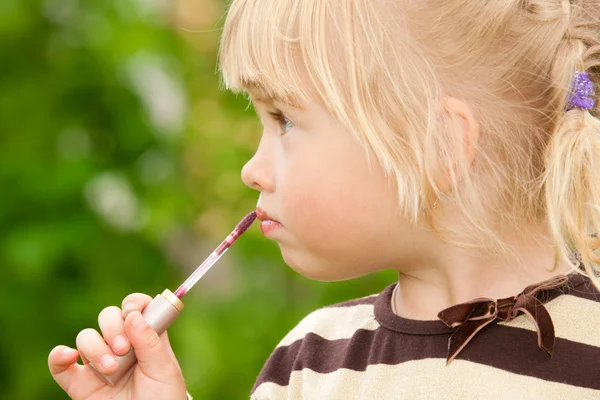 Das kleine Mädchen malt Lippen — Stockfoto
