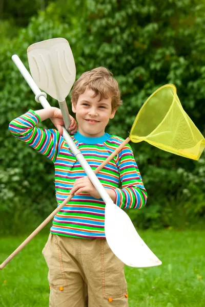 Мальчик с веслами и сетью на открытом воздухе — стоковое фото