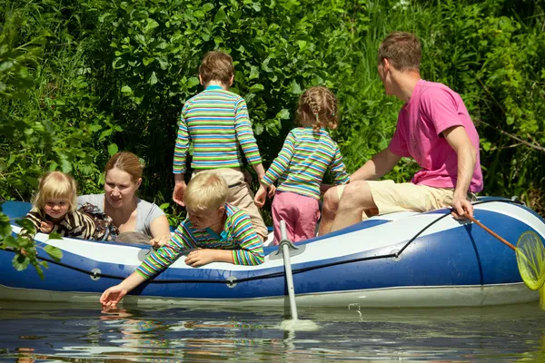 Enfants et adultes flottent sur un bateau gonflable — Photo