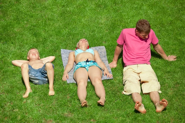 Gezin met jongen rusten op het gras, uitzicht vanaf omhoog — Stockfoto