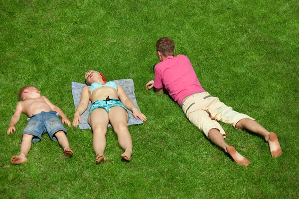 Семья с мальчиком, отдыхающим на траве, вид сверху — стоковое фото