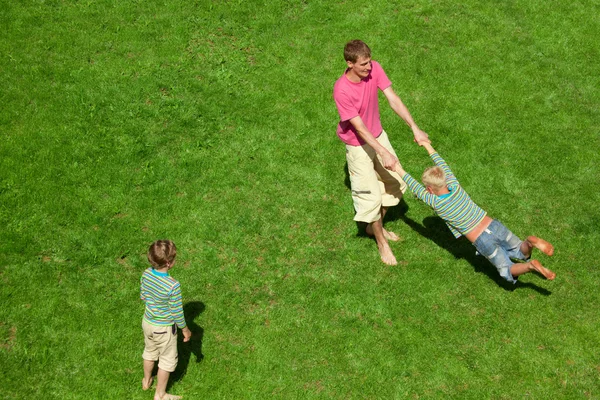 Boys play with the man outdoor. The Top view. — Stock Photo, Image