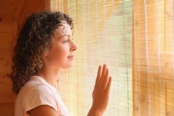 Piękna kobieta patrząc w okno — Zdjęcie stockowe
