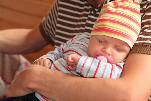 Baby sover på händerna på man — Stockfoto