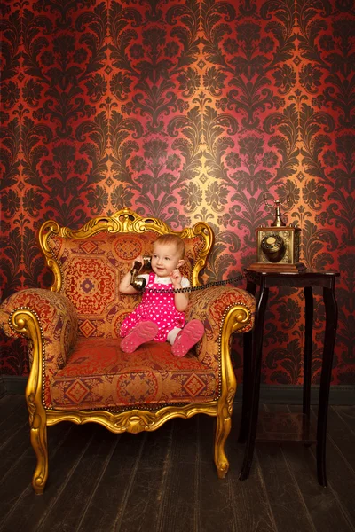 Маленькая девочка и старое кресло — стоковое фото