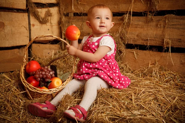 Маленька дівчинка на соломі з кошиком — стокове фото