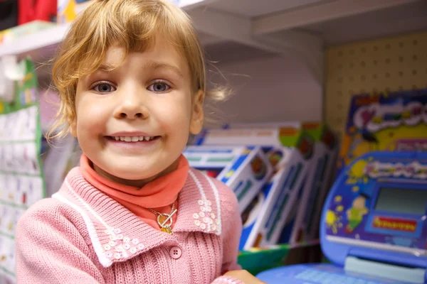 Портрет маленькой девочки у витрины игрушек — стоковое фото