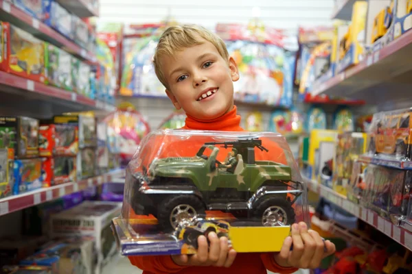 Το αγόρι στο κατάστημα με το παιχνίδι μηχανή στα χέρια — Φωτογραφία Αρχείου