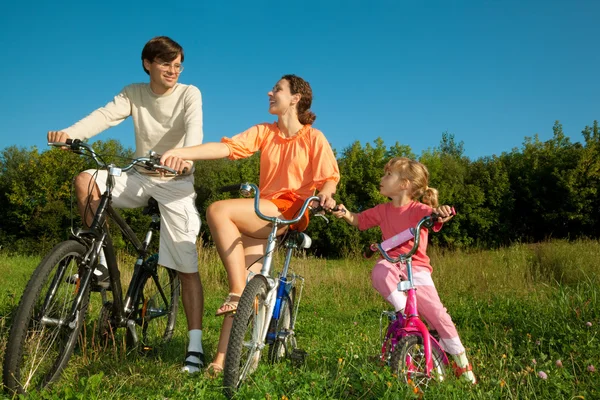 The father, mum and daughter on bicycles in park. To keep the fr — Stock Photo, Image
