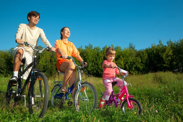 Baba, anne ve kızı güneşli günde bir disk üzerinde bicyc gitmek — Stok fotoğraf