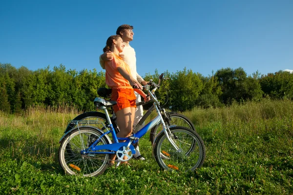 La ragazza e l'uomo con le biciclette si abbracciano . — Foto Stock